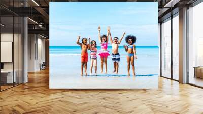 Group of Diversity little child boy and girl friends running and playing sea water at tropical beach together on summer vacation. Happy children kids enjoy and fun outdoor lifestyle on beach holiday. Wall mural