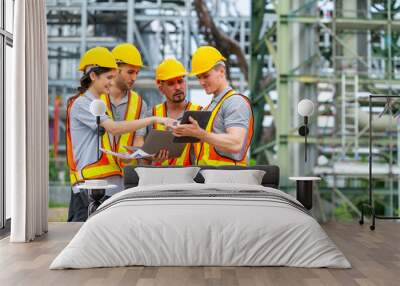 Group of Petrochemical engineers teamwork working together at petroleum oil refinery industry area. Industrial technician worker maintenance inspect manufacturing energy power gas system at factory. Wall mural