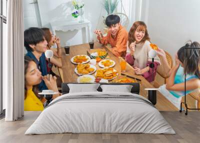 Group of Young Asian man and woman friends having dinner party eating food and drinking soft drink together at home. Happy people enjoy and fun meeting celebration party on festival holiday vacation. Wall mural