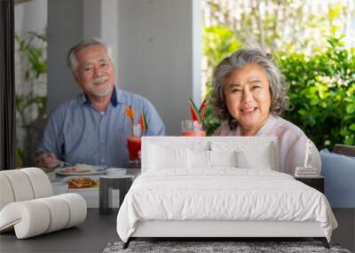 Happy Asian family senior couple having lunch and sharing meal together at restaurant. Elderly people man and woman enjoy retirement with outdoor activity lifestyle on summer holiday travel vacation. Wall mural