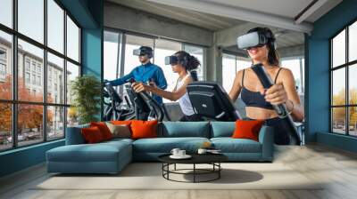 Healthy athletic man and woman wearing VR glasses workout exercise on cycling machine in virtual reality cyberspace at fitness gym. Metaverse digital entertainment technology and sport concept Wall mural