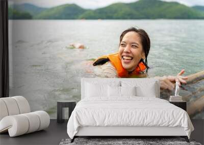 Young attractive Asian woman with life vest playing water in the lake. Happy generation z girl enjoy and fun outdoor active lifestyle travel nature at lake house on summer holiday vacation. Wall mural