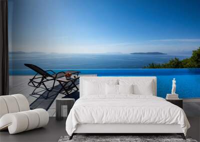 Infinity pool with chairs  With a view of the sea  Wall mural