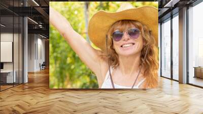 adult woman smiling happy outdoors wearing hat and sunglasses Wall mural