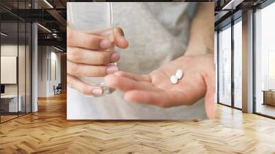 hand with medicine in pills and glass of water Wall mural