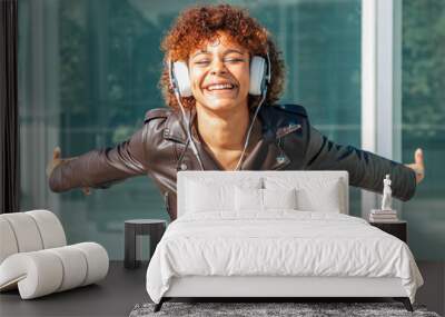 happy girl smiling with headphones on the street Wall mural