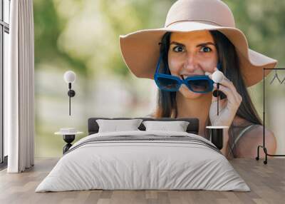 portrait of girl or young woman in hat and sunglasses outdoors in summer Wall mural