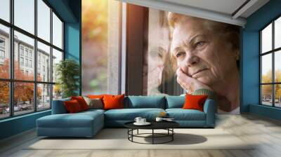 portrait of senior woman looking out the window Wall mural