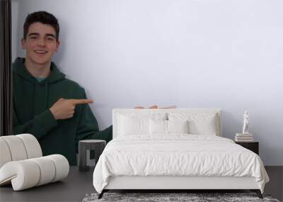 smiling isolated teenager pointing on white background Wall mural