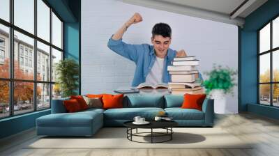 student at the desk with book and expression of success and triumph Wall mural