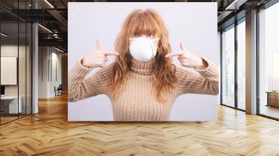 woman with mask on white wall background Wall mural