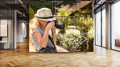 woman with photo camera taking photos in nature Wall mural