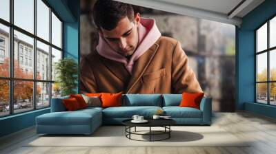 young adult man in coat on the city street Wall mural