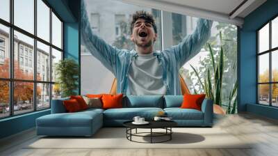 young man at home excited celebrating success Wall mural