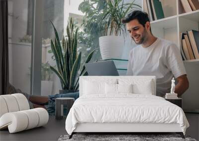 young man at home with computer and cup of coffee Wall mural