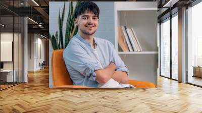 young man on the sofa at home smiling happy Wall mural