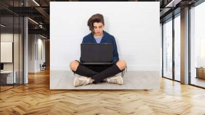 young man sitting on the floor with the laptop Wall mural