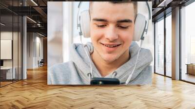 young man with headphones and mobile phone Wall mural