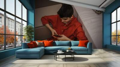 young teenage boy with mobile phone at home Wall mural