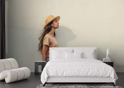 young woman or girl standing with hat and background wall on the street Wall mural