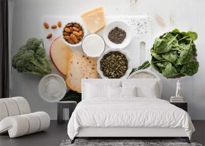 A variety of calcium rich foods including nuts, seeds, dairy and greens. Wall mural