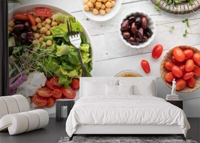 Top down view of a Greek salad bowl with all the ingredients to the right. Wall mural