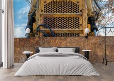 Close up of an old bulldozer at a construction site used for excavation, earthmoving, and road building. Wall mural