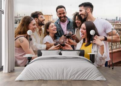 Cheerful carefree group of friends standing and toasting with wine glasses in a terrace.Diverse group of young people celebrating and drinking wine in a rooftop dinner. Wall mural