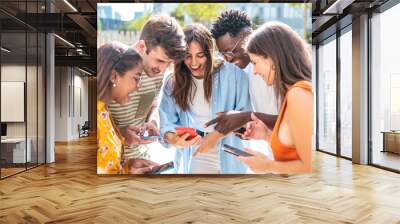 happy young friends looking mobile phone and smiling - five happy teenagers with a smartphone - Lifestyle concept Wall mural