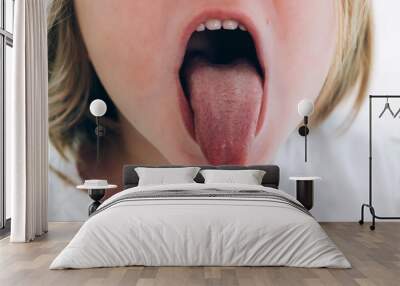 a child girl open her mouth and show her tounge Wall mural