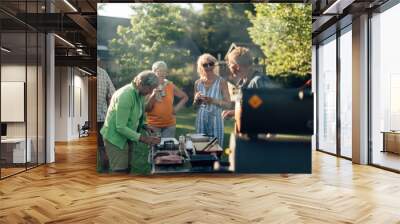 group of senior people enjoying life on a barbecue in the garden - elderly friends talk and drink outdoors Wall mural