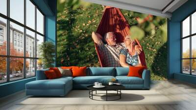 senior couple bonding on the hammock. free time together. positive retired people. Wall mural