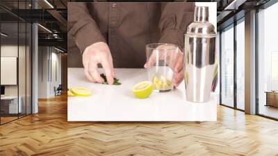 Bartender preparing mojito cocktail drink, with limes, ice and b Wall mural