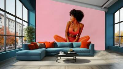 beautiful African american woman meditating in sports outfit on pink background Wall mural