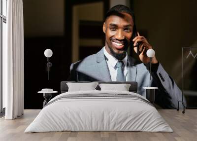 Close up portrait of a happy smiling young man in business suit holding cell phone, talking and looking at camera Wall mural