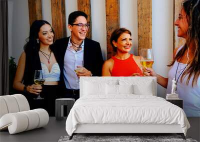 Happy male and females having wine during party at home Wall mural