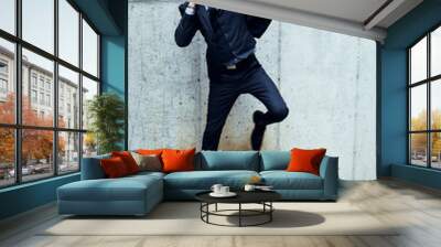 Happy man in business suit and phone jumping up with joy Wall mural