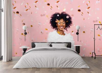 Happy woman with a big smile and confetti falling, on pink background Wall mural