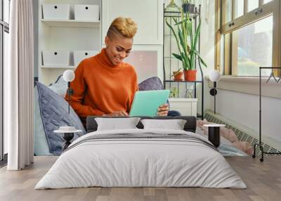 Happy Yoiung Woman Using Laptop While Sitting On Sofa At Home Wall mural