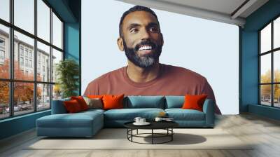 headshot portrait of a handsome bearded mid adult man smiling looking away at copy space against gray background studio shot Wall mural