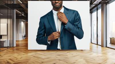 Portrait of a confident man in business suit, fixing tie Wall mural