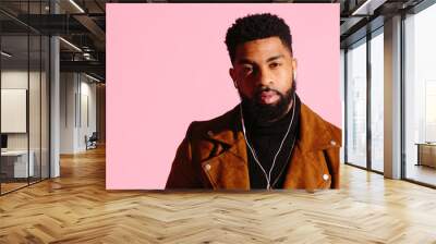 Portrait of a cool and handsome African American man with beard, isolated on pink studio background Wall mural