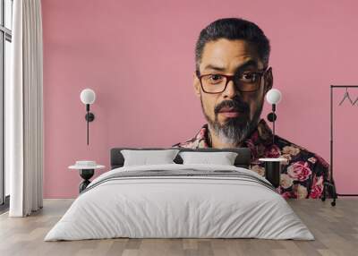 Portrait of a mature man with silver beard and glasses, isolated on pink studio background Wall mural