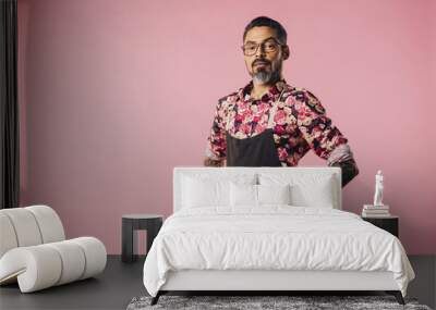 Portrait of a stylish cook with tattoos with hands on waist, isolated on pink studio background Wall mural