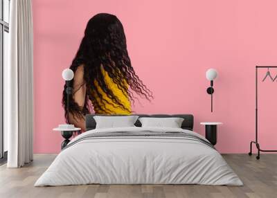 Portrait of a young female model with beautiful, healthy and very long black curly hair in studio copy space Wall mural