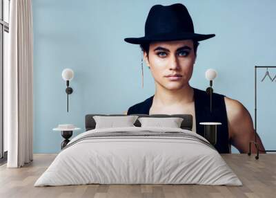 Portrait of a young man with make up, vest and  hat in studio Wall mural