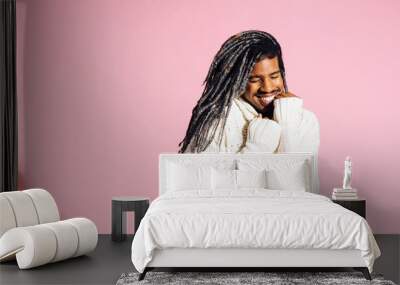 Portrait of a young smiling man with warm cozy sweater in studio Wall mural