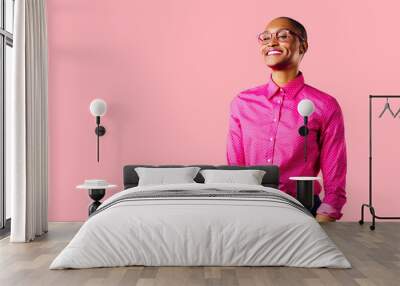 Portrait of a young smiling woman in pink shirt, isolated on pink studio background Wall mural