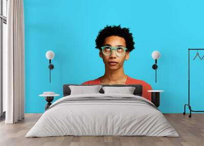 Portrait of African American man thinking looking up wearing eyeglasses and afro hair Wall mural