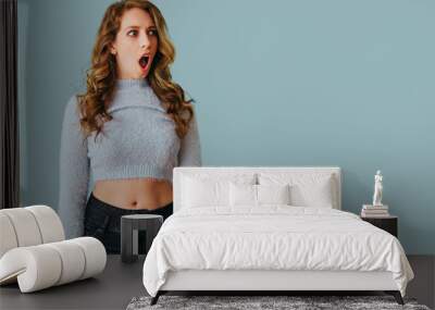 portrait of young shocked woman with long curly hair studio Wall mural